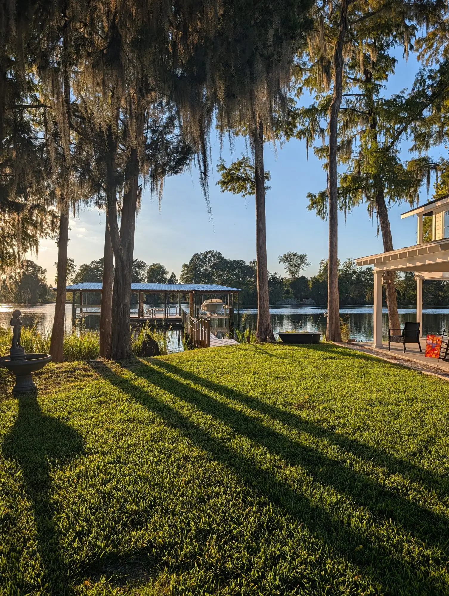 A lake lined with live oaks and Spanish moss at sunrise
